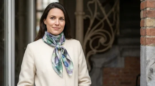 Portrait éditorial d'une femme élégante portant un carré de soie noué avec style moderne dans un décor architectural belge