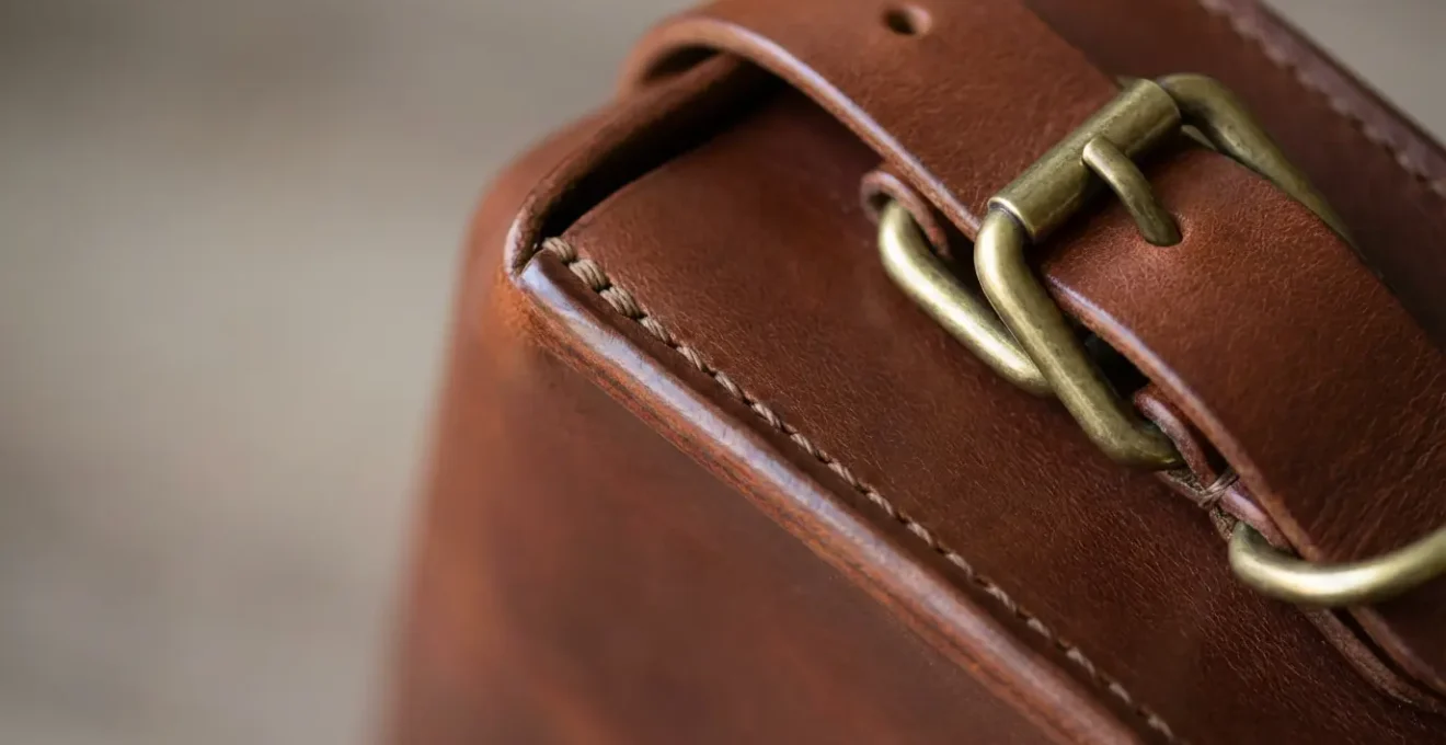 Gros plan sur les détails de qualité d'un sac en cuir montrant coutures et ferrures