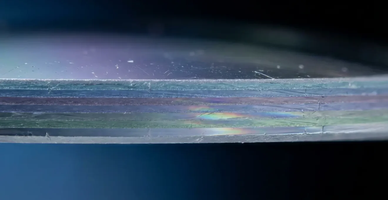 Vue macro détaillée de la surface d'un verre de lunettes montrant les couches de traitement